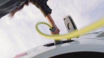 
Eine Hand steckt ein Ladekabel in ein Elektroauto.