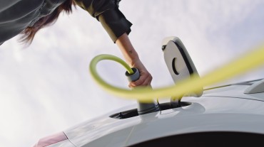 
Eine Hand steckt ein Ladekabel in ein Elektroauto.