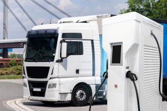 
Ein weißer Lkw wird an einer Ladestation für Elektrofahrzeuge geladen.