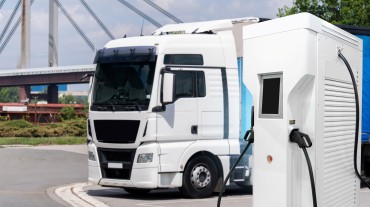 
Ein weißer Lkw wird an einer Ladestation für Elektrofahrzeuge geladen.