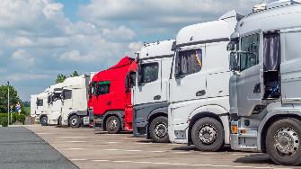 
Mehrere geparkte Lkw in einer Reihe auf einem Rastplatz