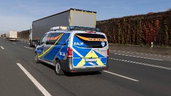 
Ein Fahrzeug der BALM-Verkehrskontrolle fährt auf einer Autobahn hinter einem Lkw.