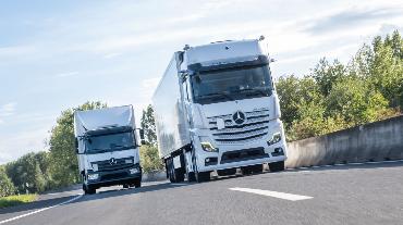 
Zwei Lkw fahren nebeneinander auf einer Straße