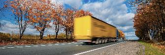 
Ein Lkw fährt im Herbst über eine Bundesstraße