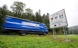 
Ein Lkw fährt bei einem Hinweisschild zur Lkw-Maut vorbei.