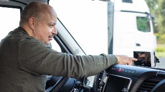 
Lkw-Fahrer bedient eine On Board-Unit im Fahrerhaus