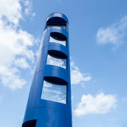 
Blaue Kontrollsäule mit mehreren Sichtfenstern für Sensoren und Kameras, mit Himmel im Hintergrund.