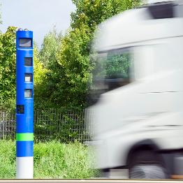 
Lkw fährt an einer Kontrollsäule vorbei.