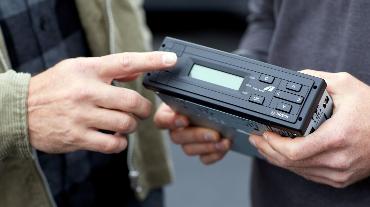 
Nahaufnahme einer On-Board Unit von Toll Collect, die in den Händen gehalten wird