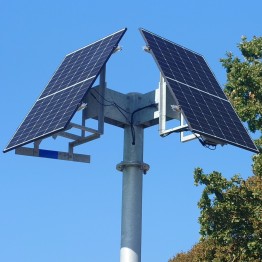 
Zwei Solarpaneele sind auf einem Mast montiert, vor blauem Himmel.