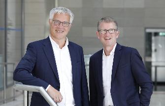 
Mark Erichsen und Dr. Rolf Erfurt stehen nebeneinander und lächeln in die Kamera