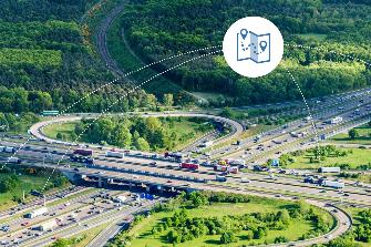 
Luftaufnahme eines stark befahrenen Autobahnkreuzes mit Icon für Navigation.