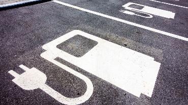 
Markierte Parkplätze mit Symbol für Elektroauto-Ladestationen.