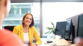 
Zwei Mitarbeiterinnen im Gespräch am Schreibtisch