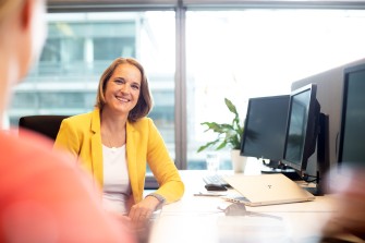 
Zwei Mitarbeiterinnen im Gespräch am Schreibtisch