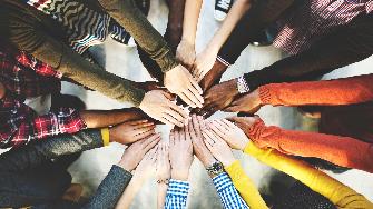 
Mehrere Hände verschiedener Personen liegen übereinander.