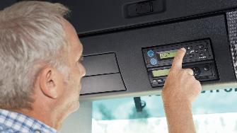 
Ein Lkw-Fahrer bedient eine Bosch-OBU, die in einen DIN-Schacht eingebaut wurde.