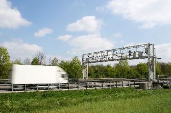 
Weißer Lkw fährt auf Kontrollbrücke zu