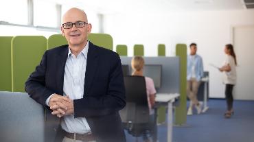 
Mitarbeiter in einem agilen Umfeld schaut in die Kamera