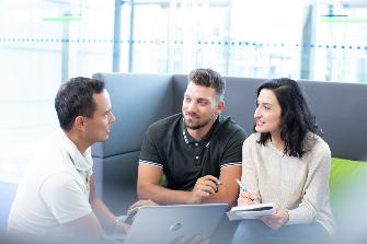 
Eine Mitarbeiterin und zwei Mitarbeiter im Gespräch