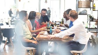 
Gruppe von Mitarbeitende an Tisch beim gemeinsamen Mittagessen