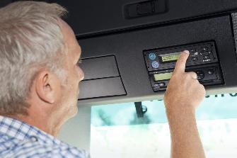 
Mann bedient On-Board Unit in Lkw-Führerhaus