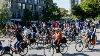 
Gruppe von Radfahrern auf einer Straße bei sonnigem Wetter.