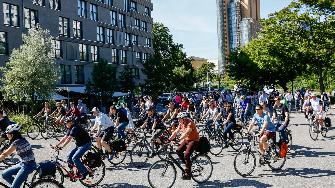 
Gruppe von Radfahrern auf einer Straße bei sonnigem Wetter.