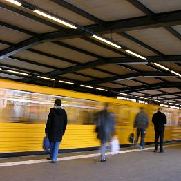 
Fahrgäste warten an einem Bahnsteig, während eine U-Bahn einfährt